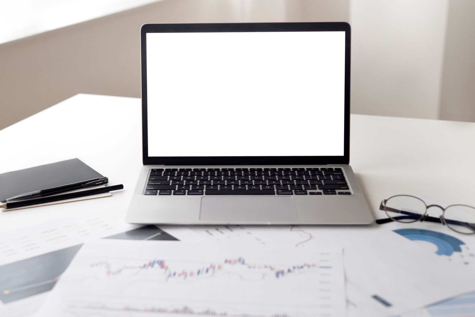 Laptop beside printed performance reports used to review ecommerce conversion tracking.
