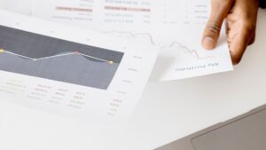 Printed performance charts being reviewed beside a laptop