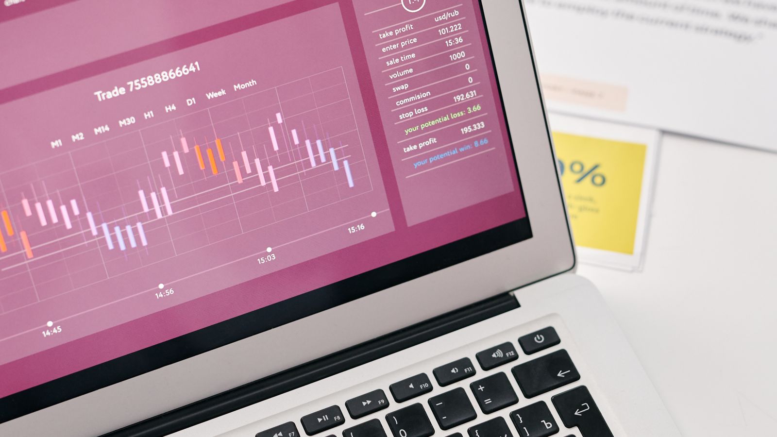 Laptop displaying analytics beside printed performance reports.