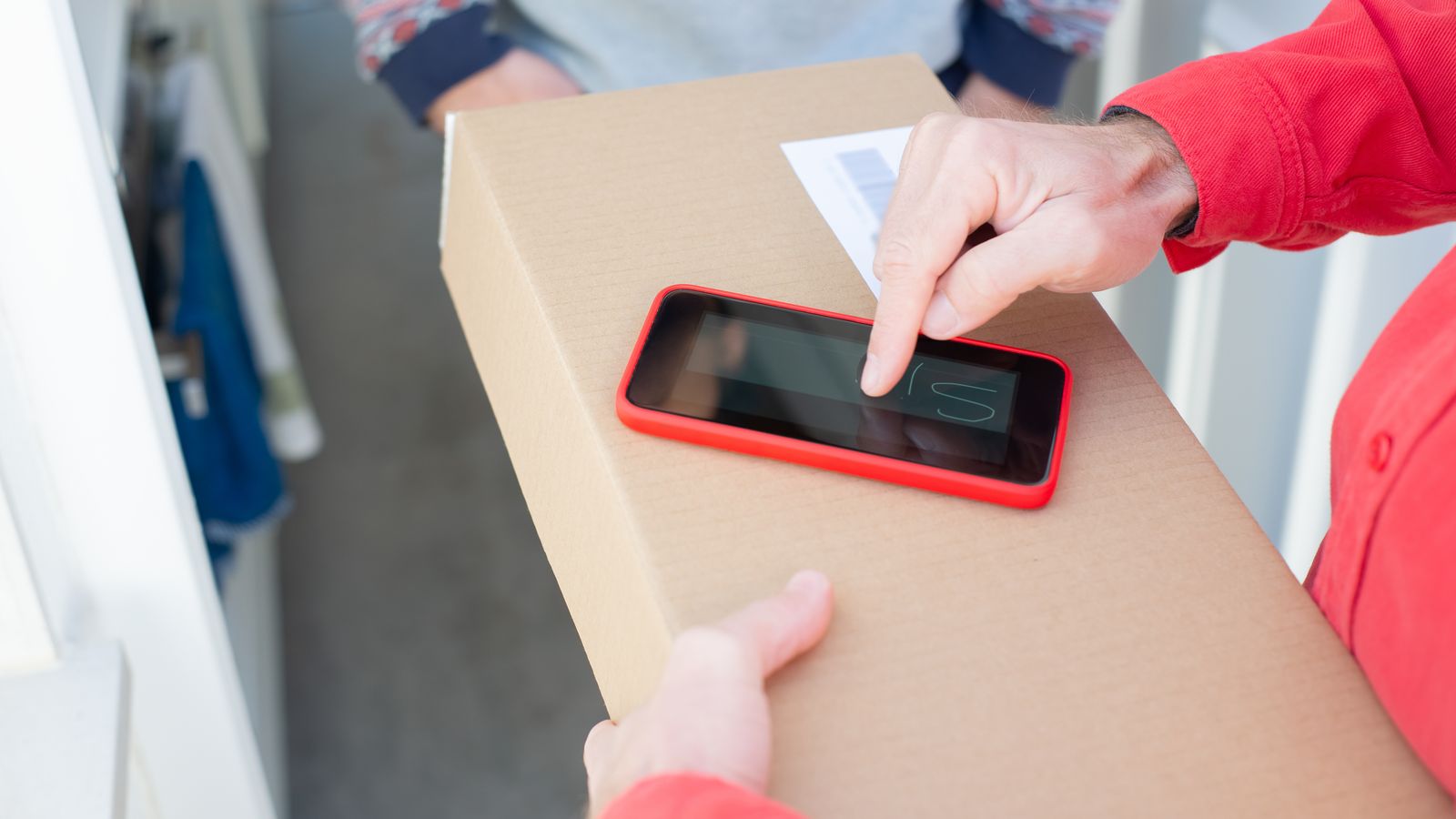 Person confirming a package delivery using a smartphone.
