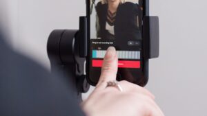 Creator recording a vertical smartphone video mounted on a stabilizer.